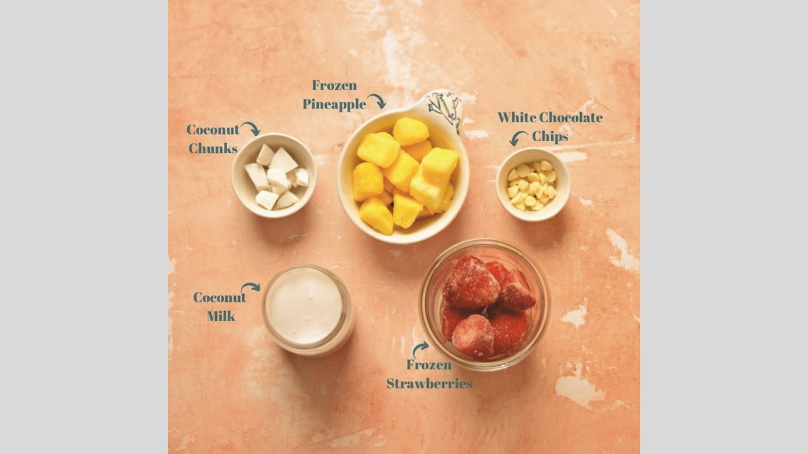 Labeled ingredient flat lay for Bahama Mama Tropical Smoothie on a peach background.