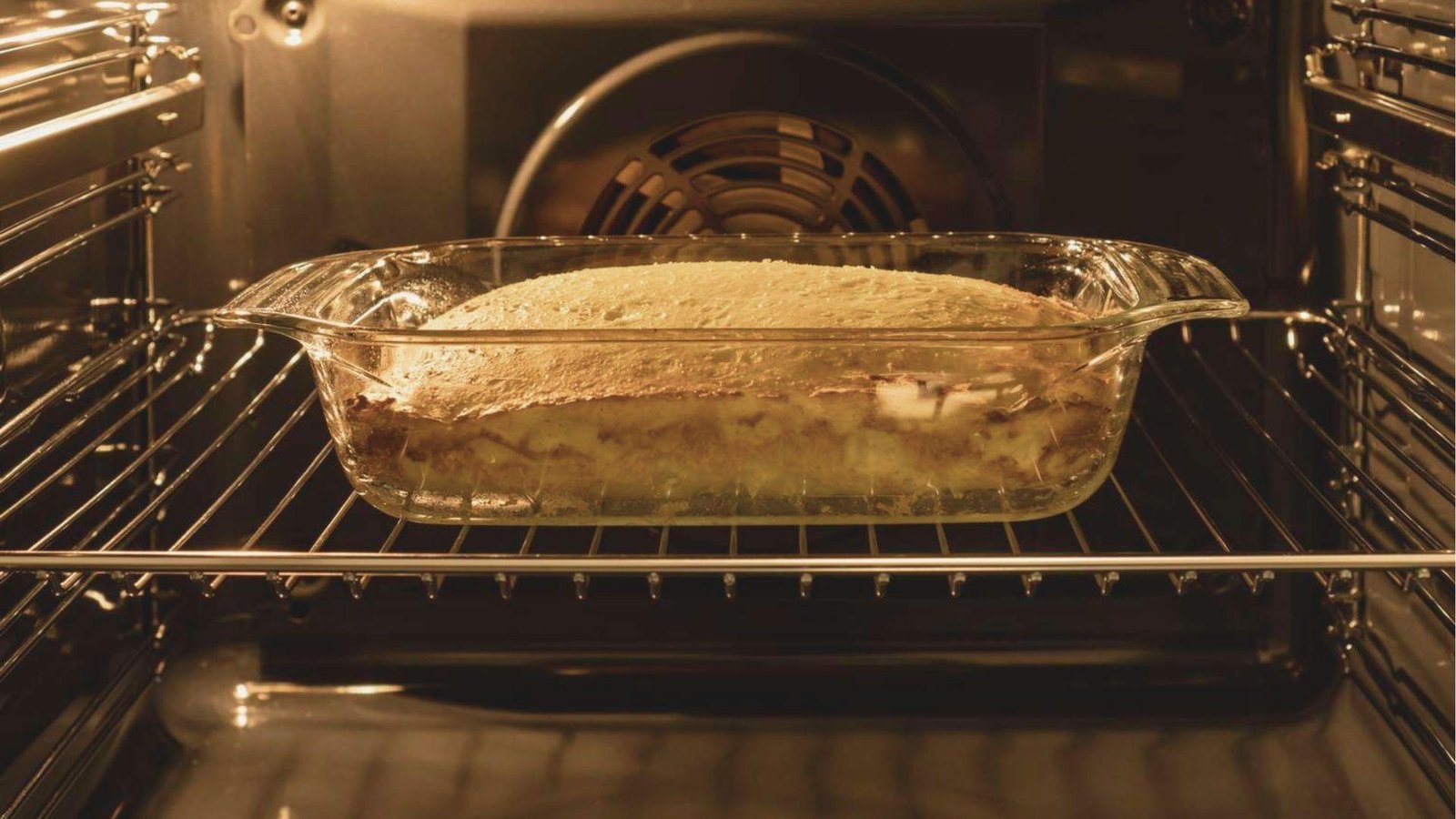 A glass baking dish of Pumpkin Crunch dessert baking in a glowing oven.