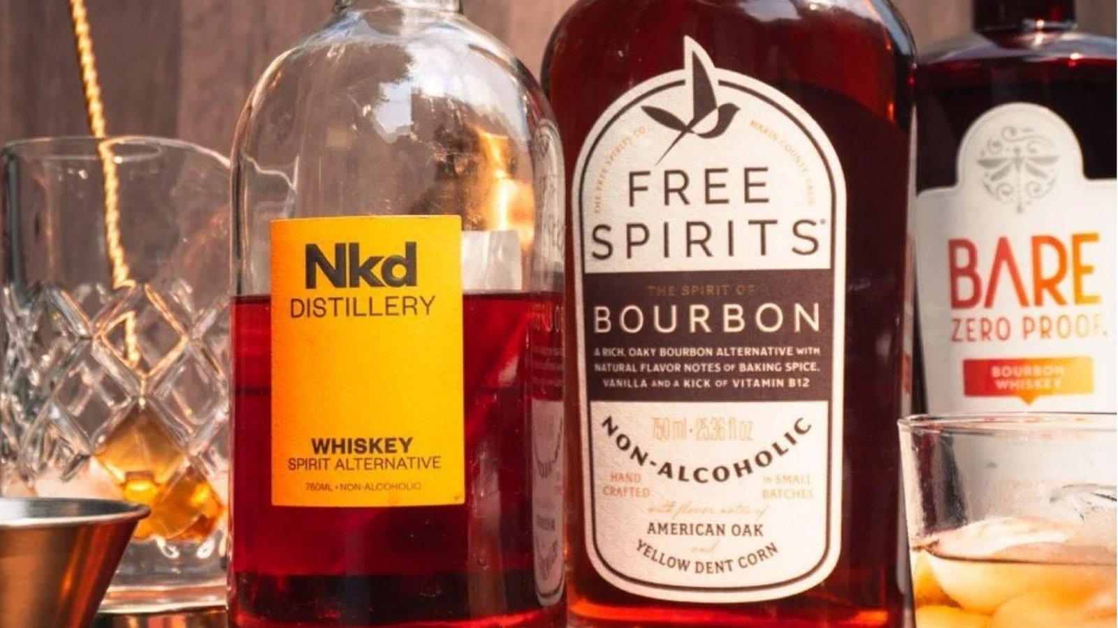 Three bottles of non-alcoholic spirit alternatives including NKD Distillery Whiskey, Free Spirits Bourbon, and Bare Zero Proof.