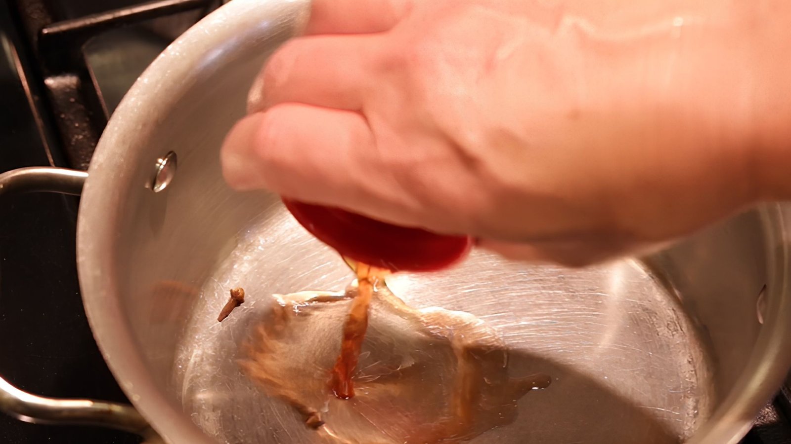 Red wine vinegar being added to a pan with warm garlic to create a tangy base for Hawaiian BBQ sauce.