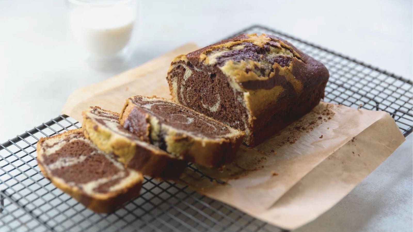 Sliced marble coffee bread loaf resting on a cooling rack over parchment paper.