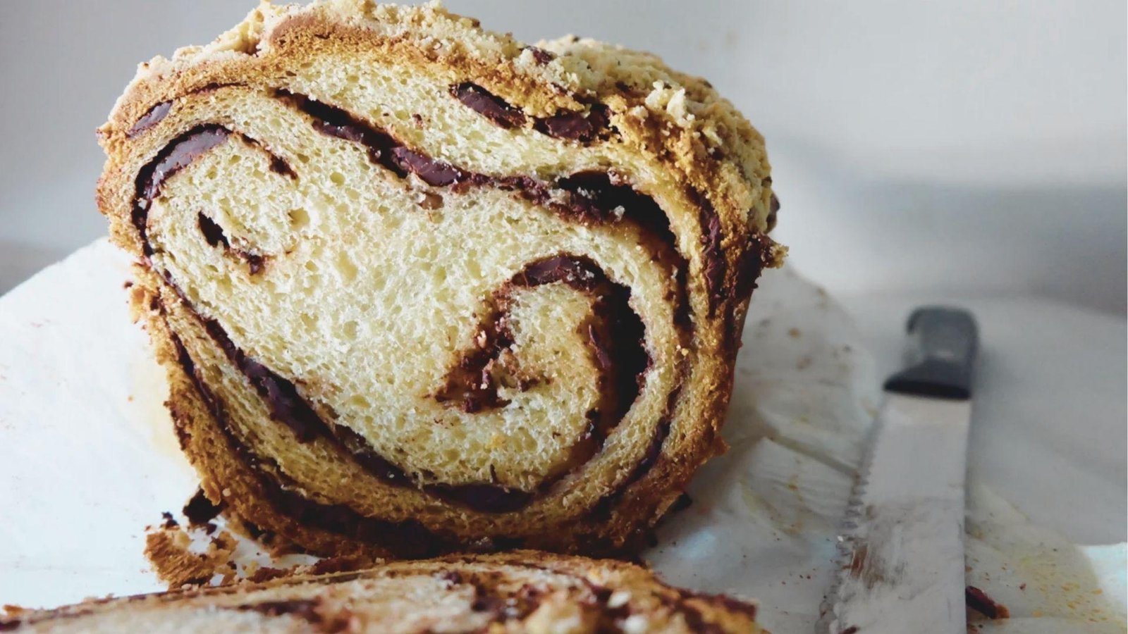Close-up of a thick slice of coffee chocolate swirl bread with a crumb topping.