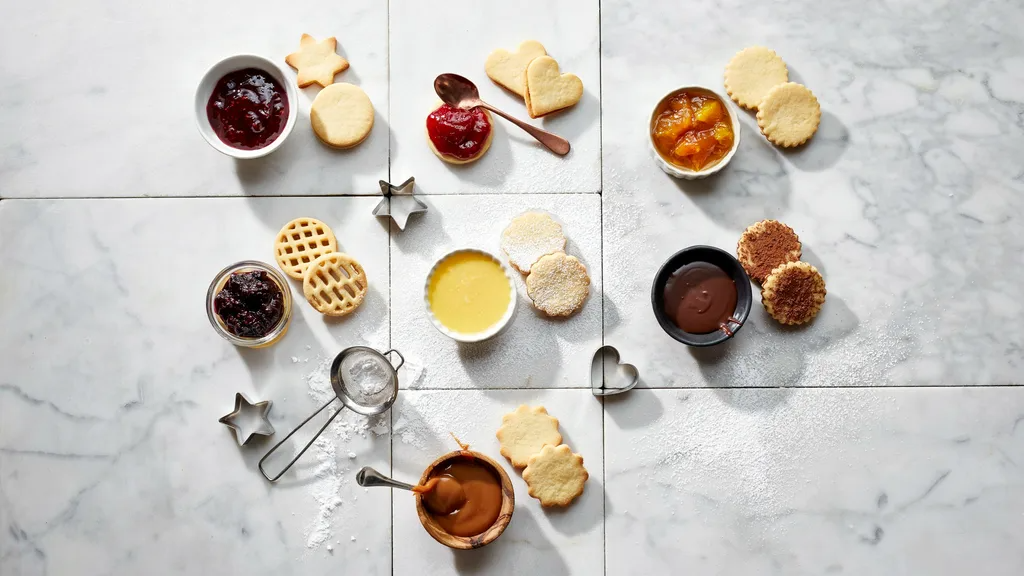 Collage of Linzer cookie fillings including jams, curd, chocolate, and caramel on baking surface.