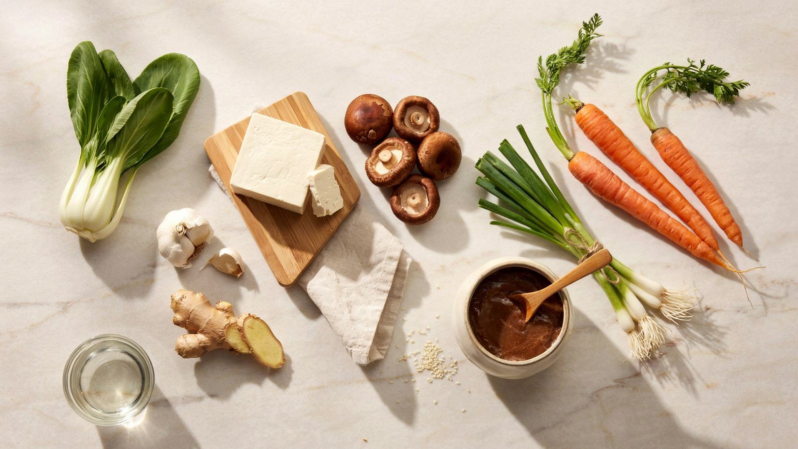 vegetables miso paste tofu garlic and ginger arranged for making vegetable miso soup.