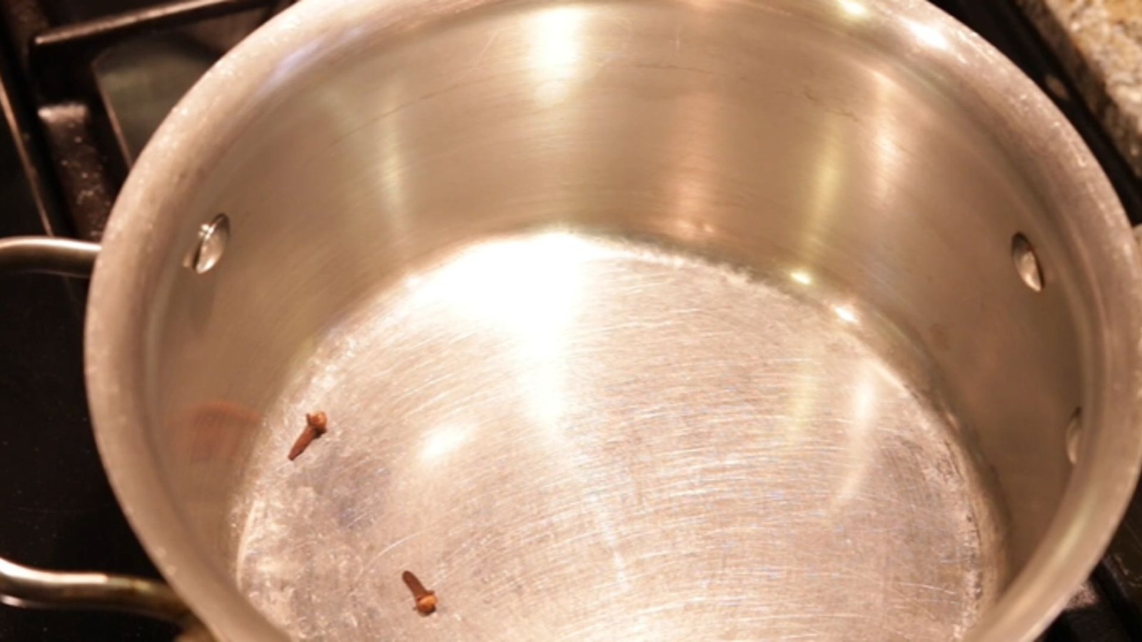 Garlic cloves heated in a pan over medium heat to build the flavor base for Hawaiian BBQ sauce.
