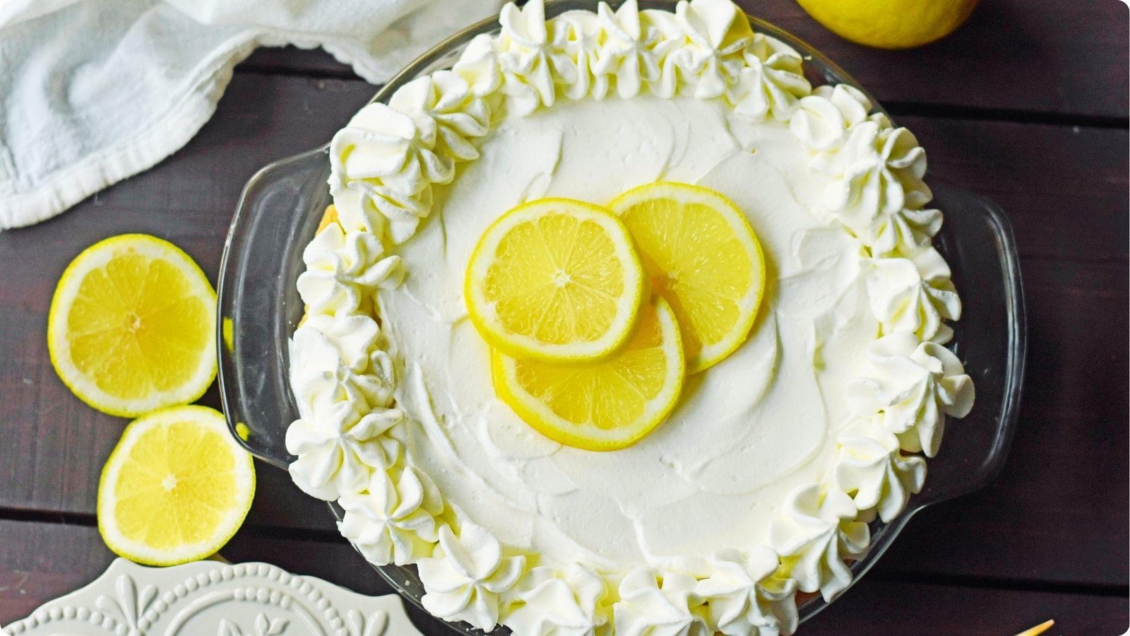 Overhead of a finished sour cream lemon pie topped with piped whipped cream border.