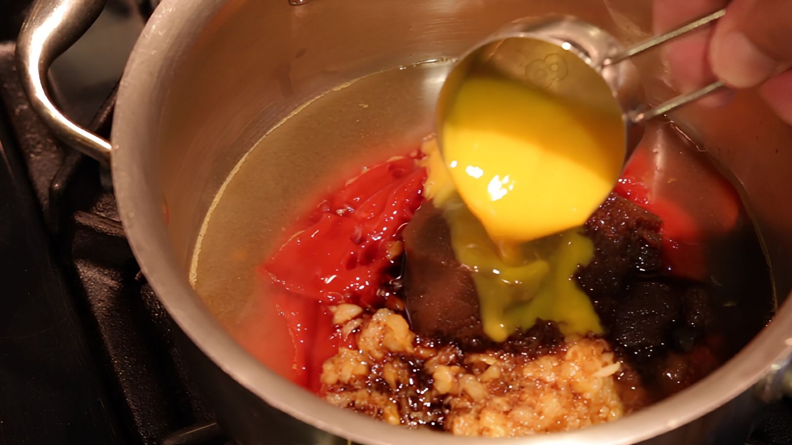 Orange juice concentrates being mixed into the sauce to add citrus flavor to Hawaiian BBQ sauce.