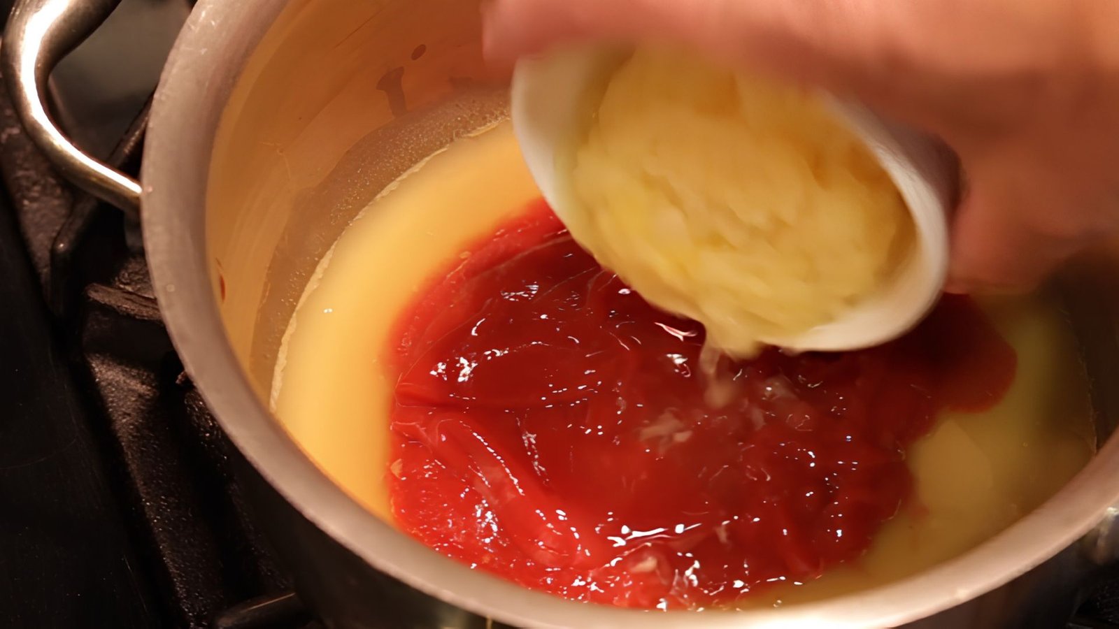 Crushed pineapple being stirred into the sauce mixture to enhance tropical flavor in Hawaiian BBQ sauce.