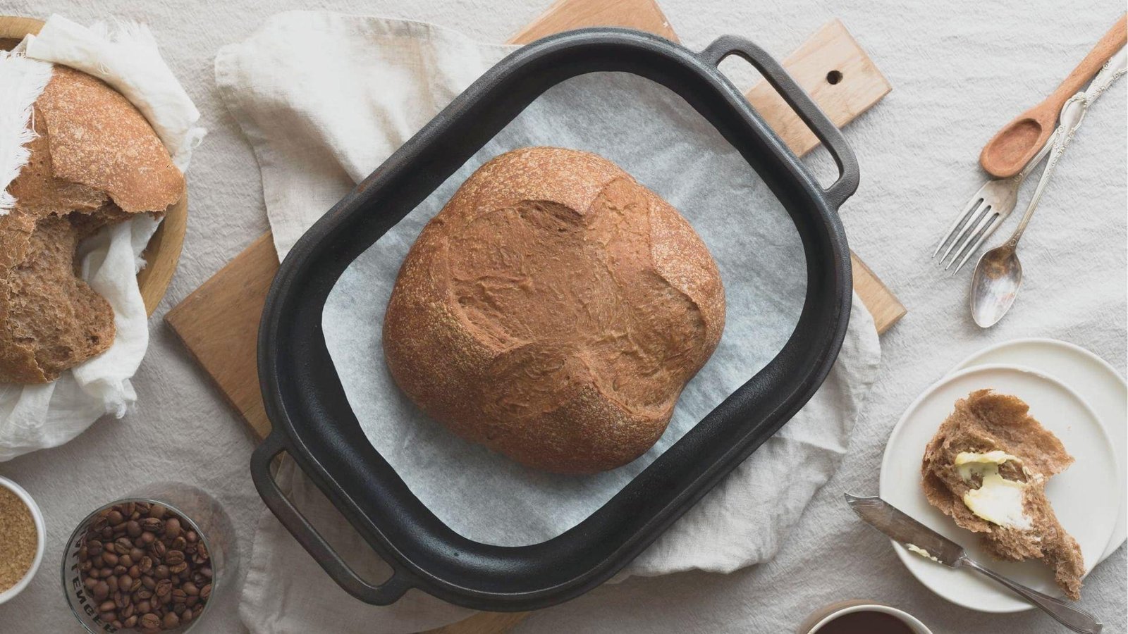 Top-down view of a rustic coffee bread loaf in a cast iron pan lined with parchment.