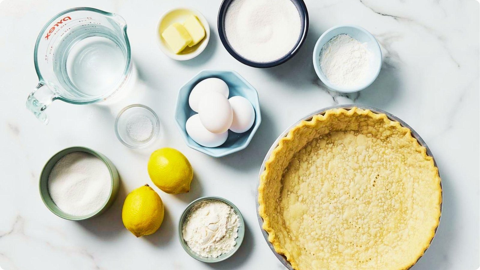 Sour cream lemon pie ingredients arranged around a graham cracker crust.