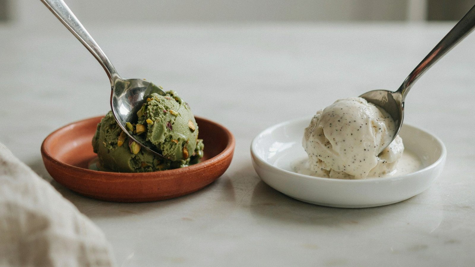 spoon cutting through gelato and ice cream showing difference in texture and melting.