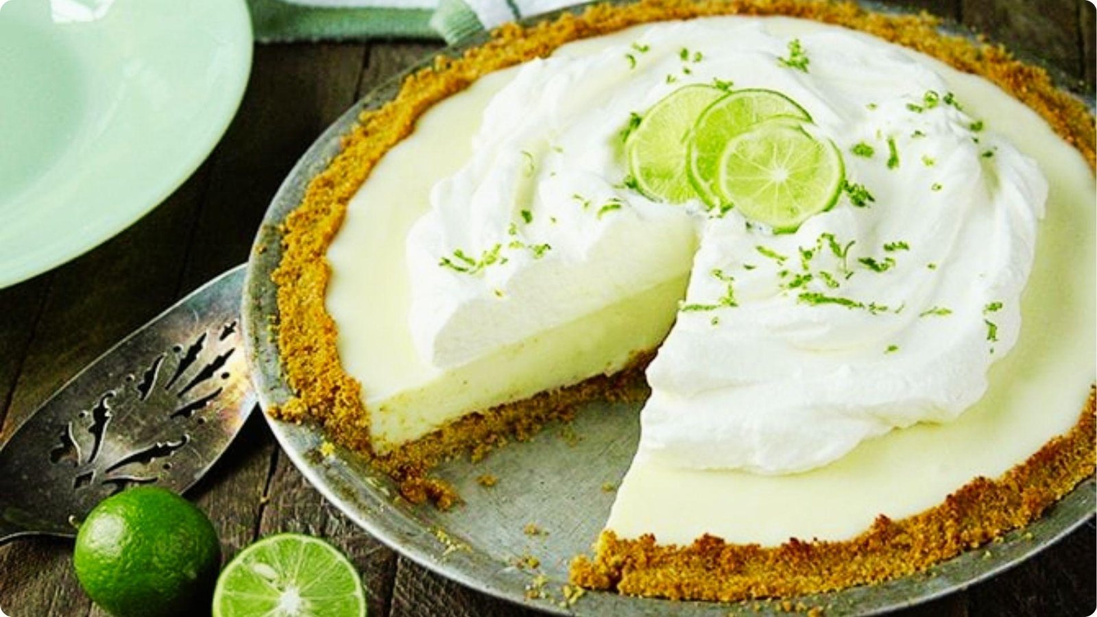 Whole sour cream lemon pie in a graham cracker crust with one slice removed.