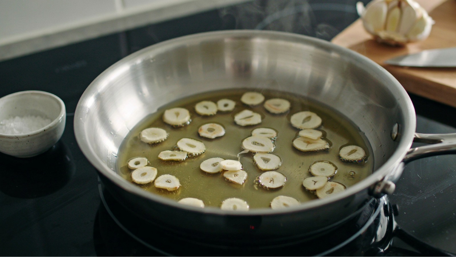 garlic slices cooking slowly in olive oil until light golden without burning.
