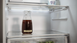brewed coffee cooling inside a refrigerator showing properly chilled coffee before blending.
